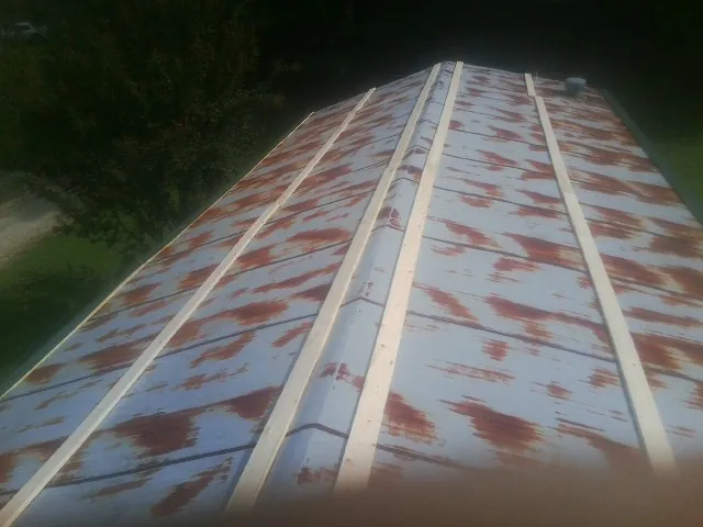 Rusted metal roof panels with new wood purlins before replacement — Storm Damage Roof Repair in Hesston by Roofing Brothers